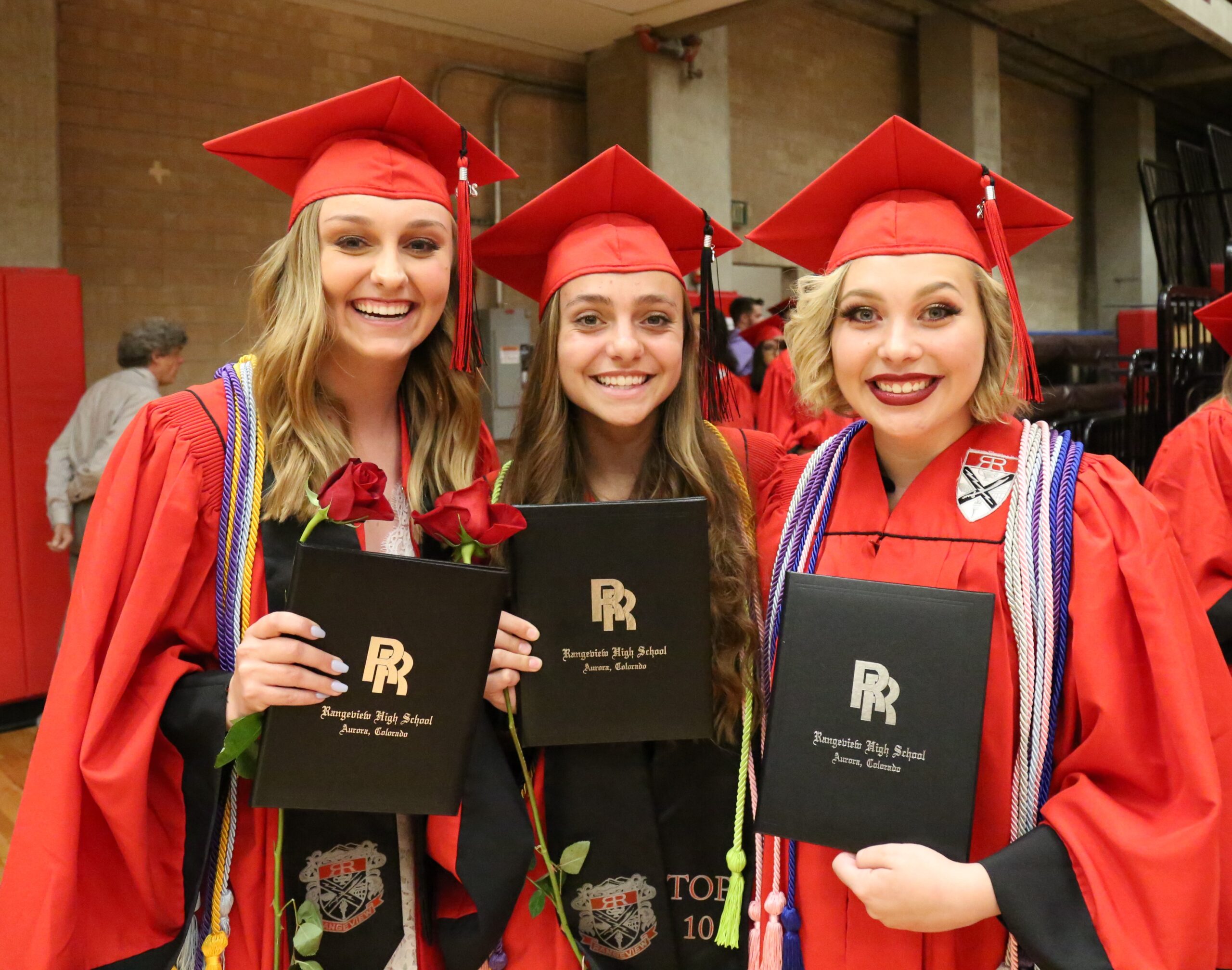 Three girls smiling at Rangeview High School graduation